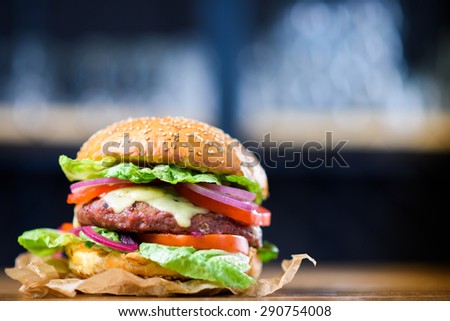 Fresh made cheeseburger with lettuce, tomato and onion.