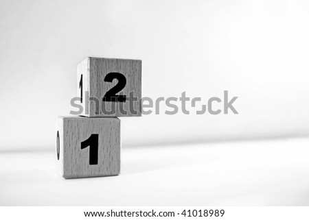 Two cubes stacked on top of each other. One numbered \'1\' and one numbered \'2\'. Metaphor for success