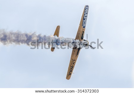 BUCHAREST, ROMANIA - SEPTEMBER 5, 2015. Aerobatic airplane pilots training in the sky of the city. Colored airplanes with trace smoke. Yak 52 airplane, aeroshow.