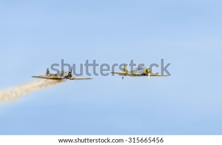 BUCHAREST, ROMANIA - SEPTEMBER 5, 2015. Aerobatic airplane pilots training in the sky of the city. Colored airplanes with trace smoke, YAK 52, aeroshow.