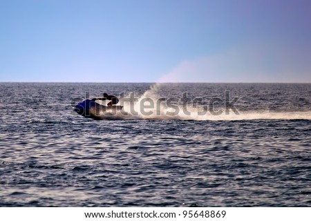 Man on jet ski silhouette, sea at late afternoon