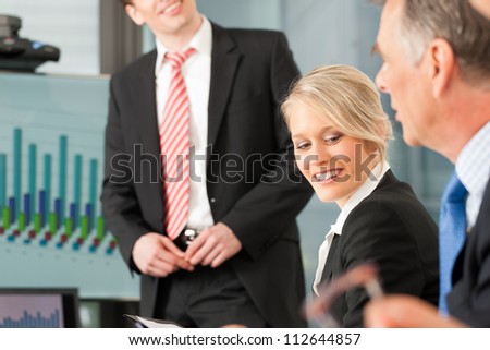 Business - presentation within a team, a male, colleague is standing on the flipchart