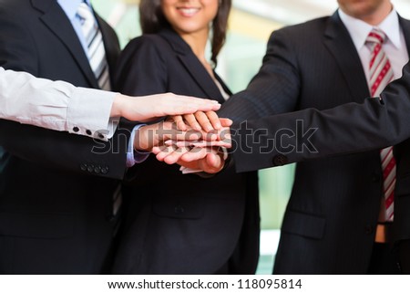 Business - group of businesspeople standing in office, they seem to be a very good team, business metaphor
