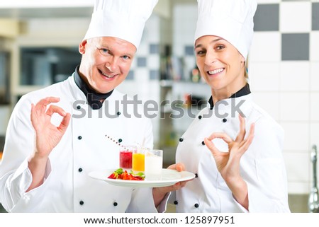 Chef team in restaurant kitchen with dessert working together