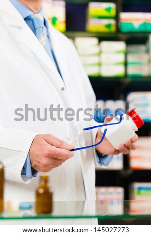 Pharmacist - only hands to be seen - standing in pharmacy with pharmaceuticals