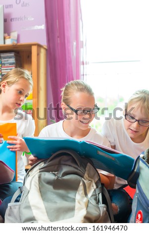 Girls or Sisters packing schoolbags with text books for school next day