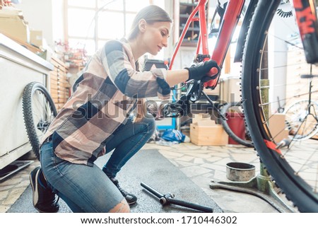 Similar – Image, Stock Photo Woman fixing bike in workshop