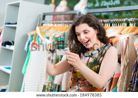 Young woman having fun while fashion shopping in boutique or store