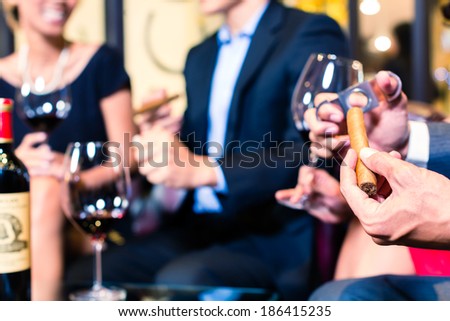 Close up of man's hand cutting cigar in restaurant