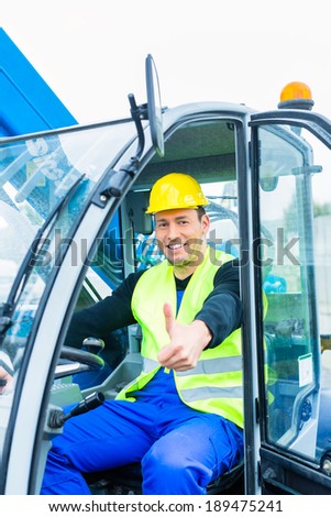 builder or driver driving excavator on construction or building site