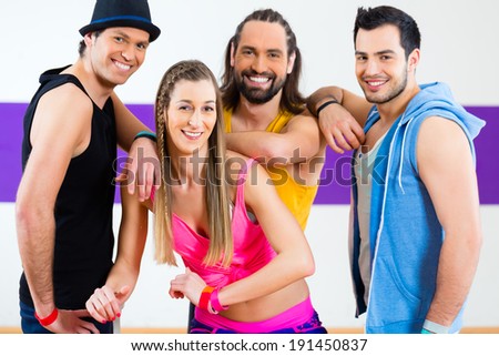 Group of men and women dancing zumba fitness choreography in dance school