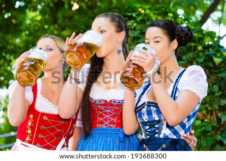 In Beer garden - female friends in Tracht, and Dirndl in Bavaria, Germany