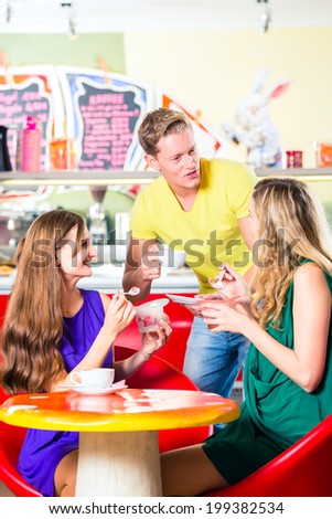 Friends meeting in ice cream parlor or cafe with cappuccino and ice-cream