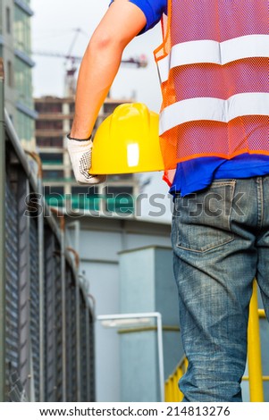 Worker on construction site with helmet or hard hat