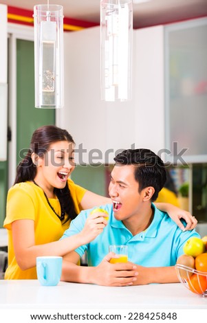 Young Asian Couple handsome woman feeding boyfriend with apple after grocery shopping