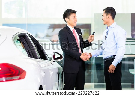 Asian Chinese Car Salesman selling auto to customer