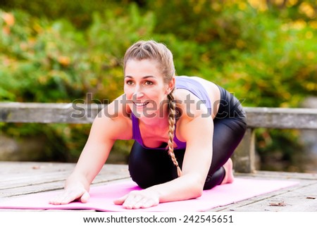 Woman training yoga outdoor in autumn or fall park