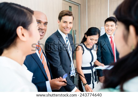 Business team meeting of Asian and Caucasian executives, Indian CEO explaining the strategy