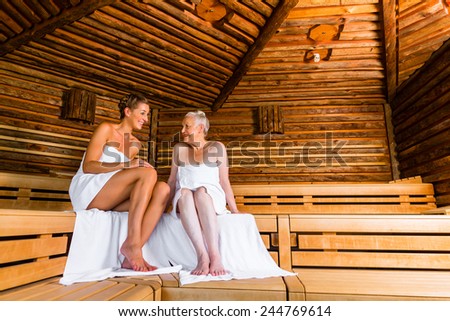 Senior and young woman in sauna sweating in heat