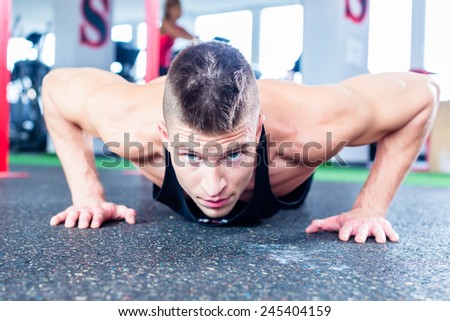 Man exercising doing push-up on floor of sport fitness gym