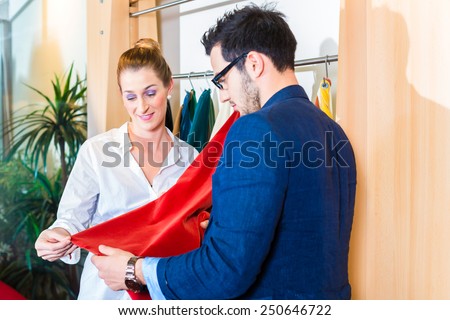 Young couple selecting seat cover for sofa in furniture store
