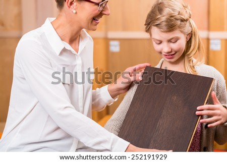 Family choosing parquet wood floor in home improvement store