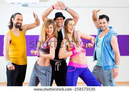 Group of men and women dancing fitness choreography in dance school