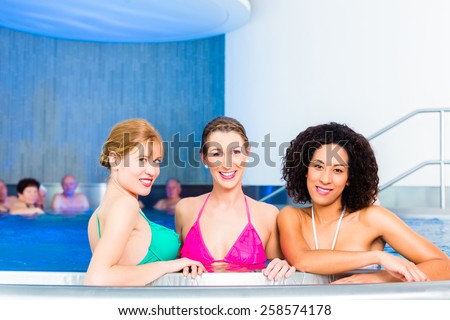 Friends wearing bikinis bathing in swimming pool
