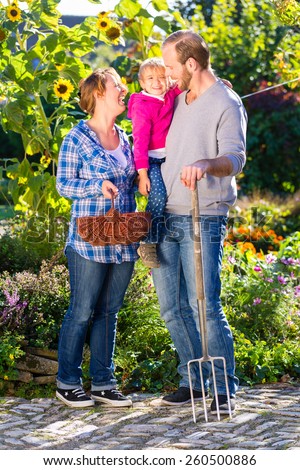 Family with mother, father and daughter gardening in garden