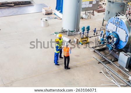 Industrial team of Worker and engineer discussing at machine in factory