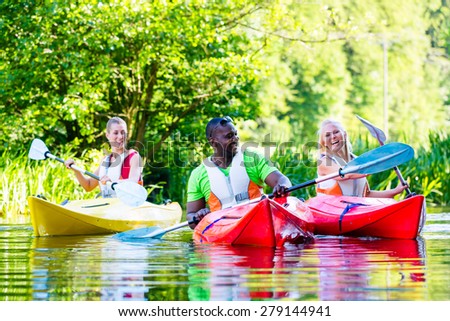Friends paddling with canoe on forest river