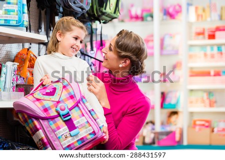 Mother and kid becoming a student buying school satchel or bag in store