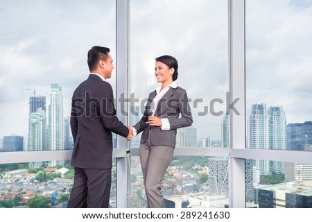 business people handshake to seal deal in front of city skyline