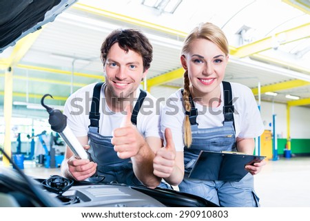 Mechanic team working in car workshop