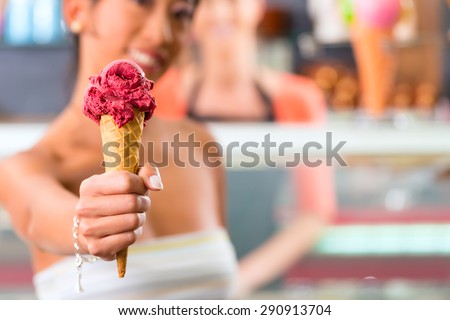 Young female customer in an ice cream parlor with ice cream cornet