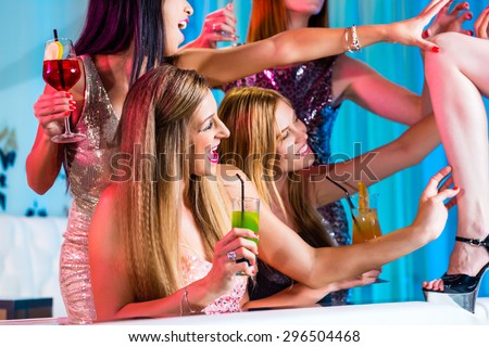 Drunk girls with fancy cocktails in strip club