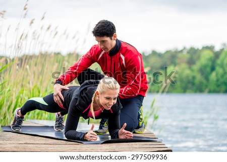 Woman with personal trainer doing fitness push-up