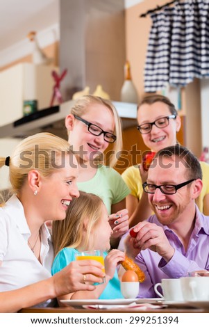 Family in their home having breakfast with eggs, fruit, coffee and juice