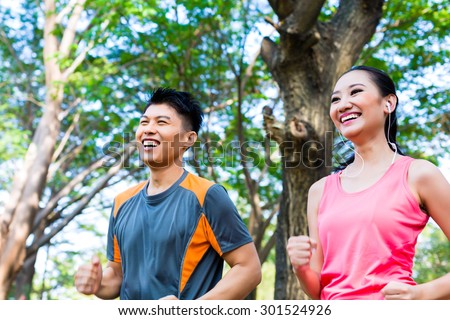 Asian Chinese man and woman jogging in city park