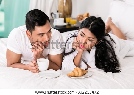 Marital issues - asian man feeling rejected by his wife, they are laying in bed