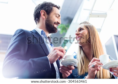 Man flirting with woman while drinking coffee