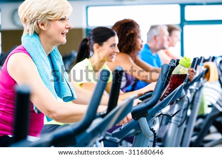 Men and women doing fitness spinning for sport, group of young and senior people