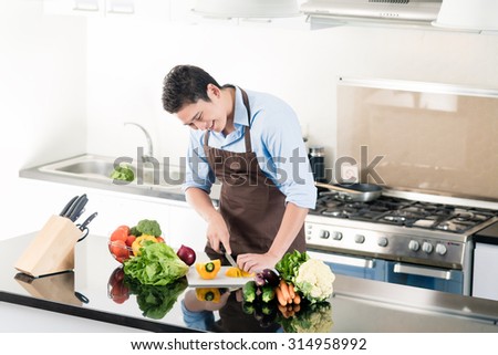 Japanese man preparing salad and cooking in kitchen