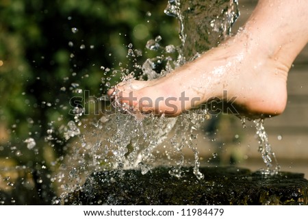 Splash of cold water showered on feet in an alternative therapy session; drops frozen