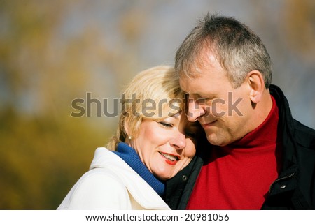 Mature couple having a walk holding each other tight still in love with each other