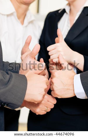 Successful business team showing a thumbs up in a meeting