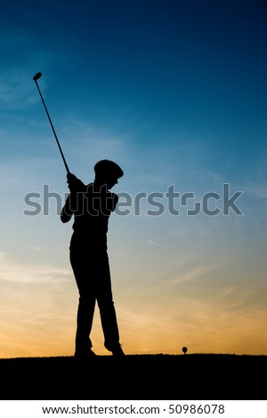 Senior woman playing golf - pictured as a silhouette against an evening sky