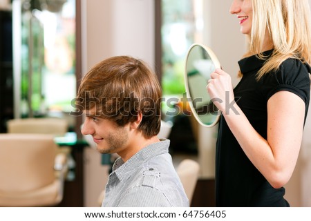 Man at the hairdresser, she has finished the cut and is showing the result in the mirror