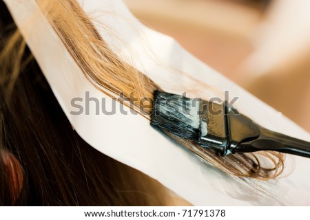 At the hairdresser Ã¢Â?Â? woman gets new hair colour; close-up on strand of hair