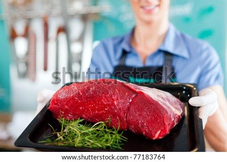 Working in a butcher\'s shop - shop assistant with meat